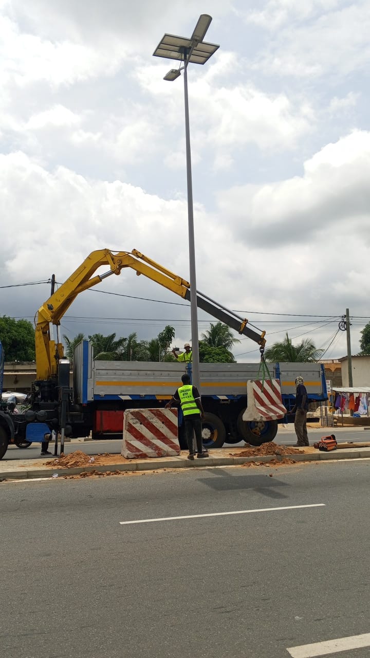 Camion-grue posant un mât d'éclairage solaire