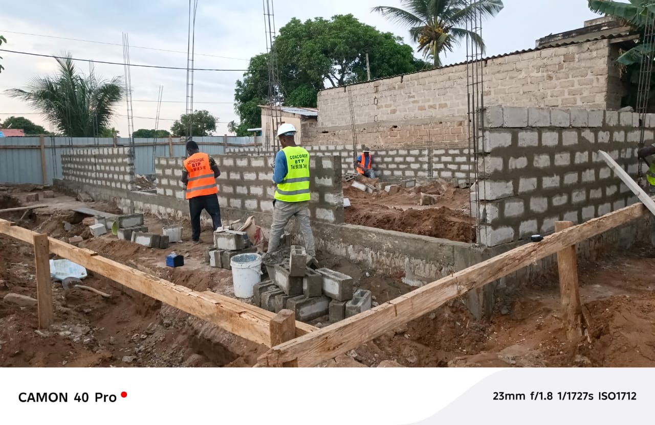 Équipe montant des murs en parpaings sur chantier